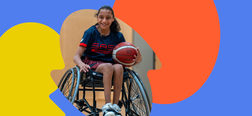 female in a wheelchair holding a basketball