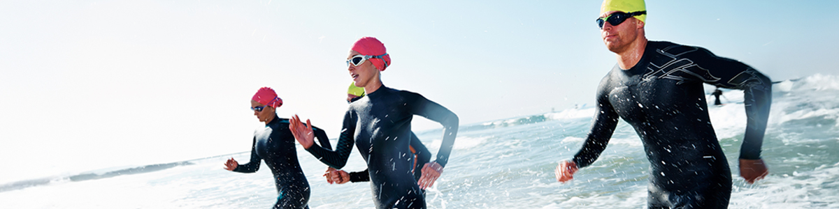 Triathletes running through the ocean water