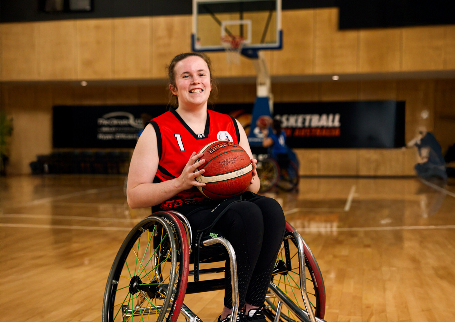 Athlete holding basketball sitting in wheelchair